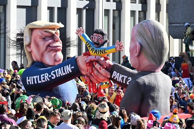 3월 3일 독일 뒤셀도르프에서 열린 로즈 먼데이 카니발 퍼레이드에서 사람들이 트럼프 미국 대통령과 푸틴 러시아 대통령을 묘사한 카니발 조형물을 지켜보고 있다. AP 뉴시스