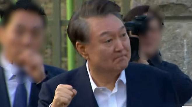 8일 오후 서울구치소 정문을 걸어서 빠져나온 윤석열 대통령이 주먹을 불끈 쥐어 보이고 있다. (SBS 캡처)