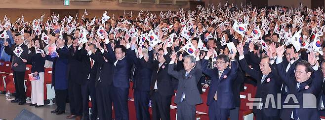 [서울=뉴시스] 조수정 기자 = 최상목 대통령 권한대행 부총리 겸 기획재정부 장관이 1일 서울 중구 숭의여자대학교에서 열린 제106주년 3·1절 기념식에서 독립유공자 후손 등 참석자들과 함께 태극기를 들고 만세삼창을 하고 있다. 오른쪽부터 이재명 더불어민주당 대표, 권영세 국민의힘 비상대책위원장, 노태악 중앙선거관리위원장, 조희대 대법원장, 우원식 국회의장, 정유헌 민족대표33인유족회 회장, 최 대통령 권한대행, 이종찬 광복회장, 독립운동가 고 오창근 선생 후손 오이환 씨, 독립운동가 고 노근우 선생 후손 강상준 씨, 독립운동가 고 박필환 선생 후손 박경준 씨. 2025.03.01. chocrystal@newsis.com