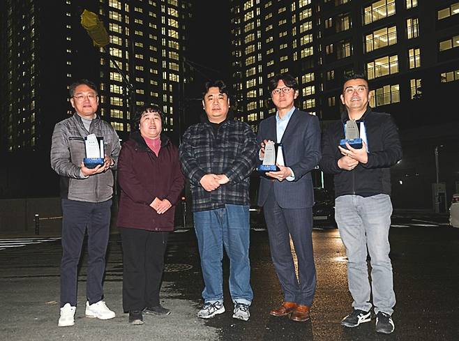 경남기업 이기동 대표이사(오른쪽 2번째)가 지난 7일 경기도 양주시 ‘장흥역 경남아너스빌 북한산뷰’에서 진행된 입주 기념 점등식에서 김국지 입주예정자협의회장(가운데)을 비롯한 입주예정자들과 감사패를 들고 기념촬영을 하고 있다.(경남기업 제공)
