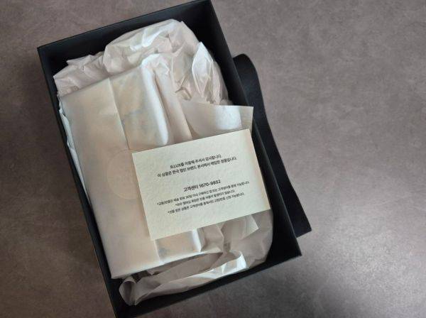 검은 상자 안에 동봉된 제품 모습. 카드에는 한국 법인 브랜드 본사에서 매입한 정품이라는 표기가 쓰여져 있다. 이민지 기자.