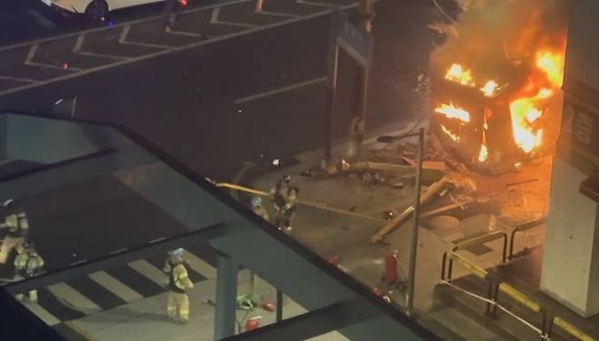 충돌 사고로 도로에서 밀려나 불이 난 택시.  연합뉴스