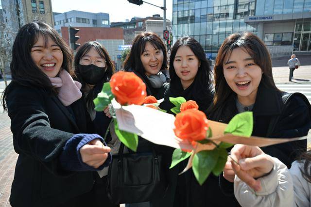 숙명여대 학생들이 지난해 3월 8일 세계 여성의 날을 맞아 서울 용산구 숙명여대에서 한국여성의전화 활동가들이 나눠준 장미를 받고 함박웃음을 짓고 있다. 한국일보 자료사진