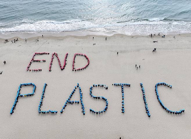 부산 해운대 해수욕장에서 16개 환경단체로 구성된 '플뿌리연대'(플라스틱 문제를 뿌리 뽑는 연대) 회원들이 'END PLASTIC' 글귀를 만드는 휴먼사인 퍼포먼스를 하고 있다. 2024.11.24. 사진=연합뉴스