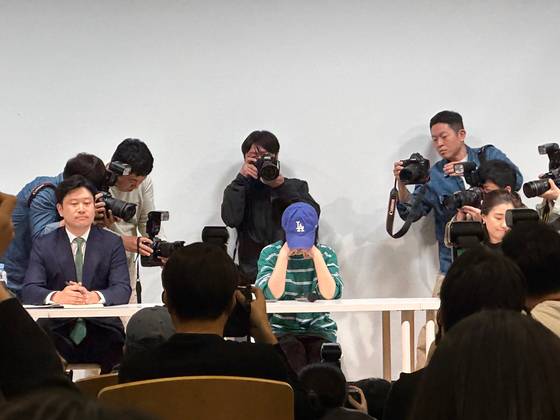 Photo journalists take close-up photos of ADOR CEO Min Hee-jin as she sits down for her press conference Thursday in southern Seoul. [CHO YONG-JUN]