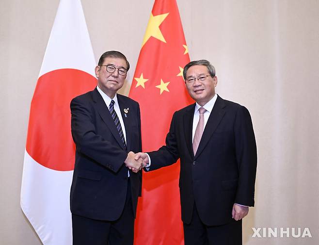 [비엔티안=신화/뉴시스] 우장하오 주일 중국대사는 연내 일본에서 열리는 한중일 정상회의에 대해 "우리는 참가한다"며 참석 가능성을 언급했다. 사진은 지난해 10월 10일(현지 시간) 라오스 비엔티안에서 악수하는 포즈를 취하고 있는 리창 중국 총리(오른쪽)와 이시바 시게루 일본 총리. 2025.03.11