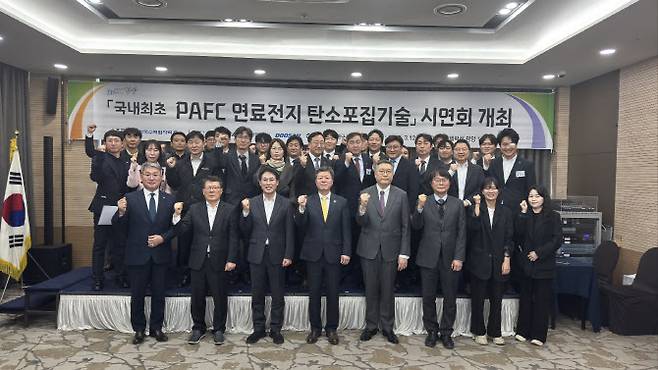 한국수력원자력과 광양시청, 여수광양항만공사, 두산퓨얼셀, 에어레인 등 관계자가 12일 전남 광양 연료전지 발전시설에서 열린 탄소포집기술 시연회에서 기념촬영하고 있다. (사진=한수원)