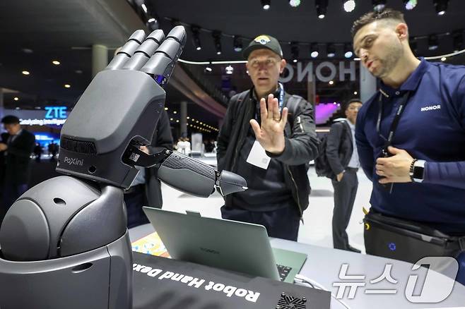 4일(현지시간) 스페인 바르셀로나 피라 그란 비아 전시장에서 열린 '모바일 월드 콩그레스(MWC) 2025'를 찾은 관람객들이 아너(HONOR) 부스에서 카메라로 사용자를 인식해 똑같이 반응하는 로봇팔을 체험하고 있다. MWC는 전세계 800여 개의 이동통신사가 참여하는 세계이동통신사업자연합회(GSMA)가 주관하는 행사로, 미국과 독일에서 각각 열리는 CES, IFA와 함께 3대 전자·IT 전시회로 꼽힌다. 올해 MWC에 참가하는 한국 기업은 187곳으로 지난해보다 22곳이 늘었다. 2025.3.4/뉴스1 ⓒ News1 민경석 기자