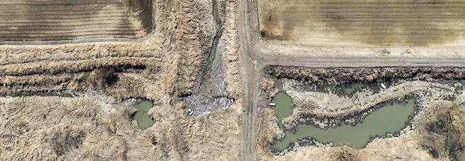 A drone survey on Mar. 6 captured a waterway in Janghang Wetland, Goyang, clogged with plastic, Styrofoam, and branches. If left unaddressed, the debris could threaten the ecosystem and affect Hangang River’s water quality. /Kim Ji-ho