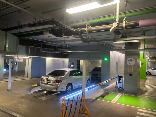 5일 태국 방콕 카농구의 대형 쇼핑몰 위즈돔101에 차량이 주차되고 있다. 운전자가 원형의 턴테이블에 차를 대기만 하면 두 대의 ‘듀오 로봇’이 기어 나와 네 바퀴를 들어올려 주차를 한다. 이때 턴테이블이 180도 돌아 리프트에 태우기 전 차량의 방향도 바꾼다. [방콕 = 이윤식 기자]