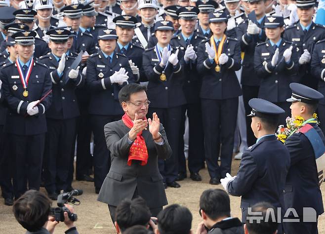 [청주=뉴시스] 조수정 기자 = 최상목 대통령 권한대행 부총리 겸 기획재정부 장관이 12일 청주 공군사관학교에서 제73기 졸업 및 임관식을 마친 뒤 선물받은 공군의 상징 빨간 머플러를 목에 두르고 박수치고 있다. (대통령실통신사진기자단) 2025.03.12. chocrystal@newsis.com