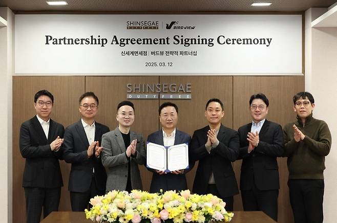 지난 12일 서울 중구 신세계디에프 본사에서 열린 신세계면세점과 뷰티 플랫폼 '화해' 운영사인 버드뷰의 전략적 파트너십 체결식에 참석한 이정욱 신세계디에프 상품본부장 전무, 양호진 영업본부장 전무, 이웅 버드뷰 대표, 유신열 신세계디에프 대표, 김경일 버드뷰 대표, 채정원 MD담당 상무, 정시욱 글로벌 비즈니스 총괄(왼쪽부터)이 기념촬영을 하고 있다(신세계면세점 제공).