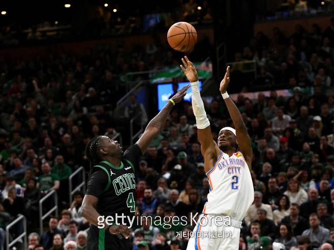 오클라호마 길저스-알렉산더(오른쪽)가 13일 TD 가든에서 열린 보스턴과의 2024~25 NBA 정규리그 원정 경기 중 보스턴 할러데이 앞에서 3점슛을 시도하고 있다. 사진=게티이미지