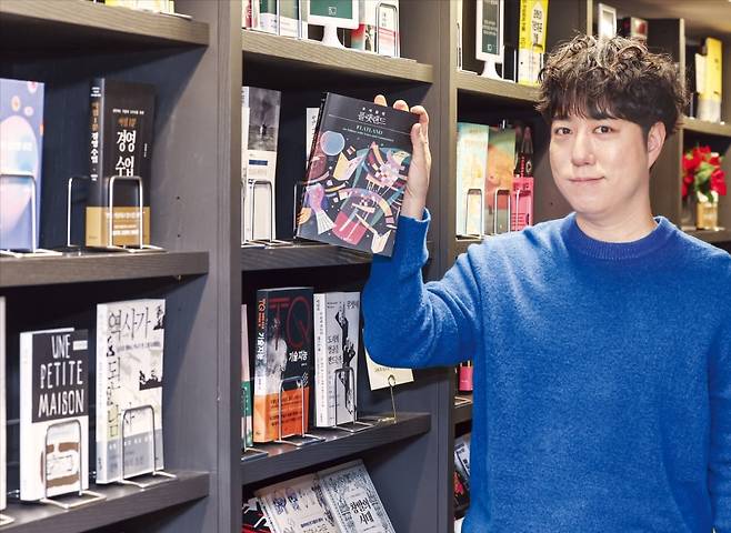 과학 커뮤니케이터 궤도가 서울 역삼동 ‘북쌔즈’에서 한국경제신문과 인터뷰하던 중 책꽂이에서 발견한 <플랫랜드>를 꺼내 들고 있다. 이 책은 유클리드 기하학이라는 수학적 소재로 SF 세계를 만든다는 내용을 담고 있다. /임형택 기자