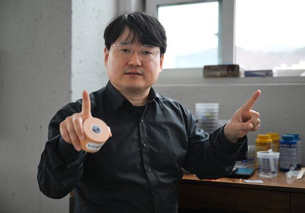 김태훈 피티브로 대표가 “부산대에서 기술이전 받은 신물질을 적용해 성능과 안정성이 뛰어나다”며 자사의 ‘다이나믹 포웨이’ 스포츠 테이프를 소개하고 있다.   전민철 기자 jmc@kookje.co.kr