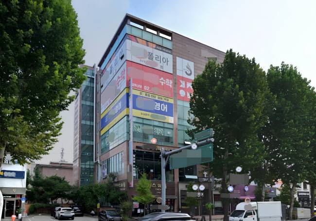 서울 송파구 한 건물 4층부터 6층까지 유리벽면 전체에 다양한 색상의 광고 시트지가 부착돼 있다.   네이버 지도 캡처