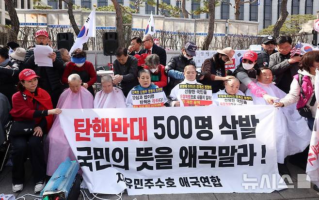 [서울=뉴시스] 김선웅 기자 = 헌재의 윤석열 대통령에 대한 탄핵심판 선고가 임박한 13일 서울 종로구 헌법재판소 앞에서 친 윤 성향 시민들이 탄핵을 반대하며 삭발을 하고 있다. 2025.03.13. mangusta@newsis.com