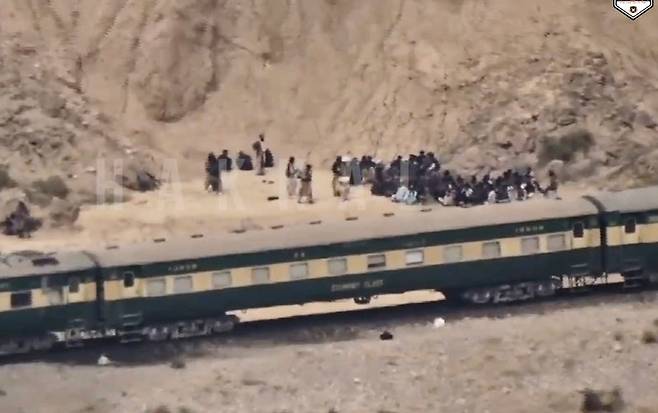 파키스탄 발루치스탄주 퀘타를 출발한 열차의 승객들이 발루치스탄해방군(BLA)의 공격을 받은 뒤 12일 열차 밖에 나와 있다. 퀘타=AP 뉴시스