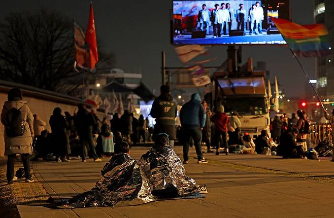 경기도 하남시에서 초등학교 5학년생 아들 최아진군과 함께 온 박상민씨가 추운 듯 은박지로 몸을 두르고 있다.