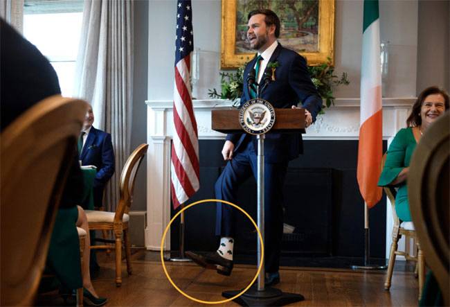 J D 밴스 미국 부통령이 12일(현지시간) 미할 마틴 아일랜드 총리와의 조찬에서 자신이 신은 양말을 자랑하고 있다.   AFP 연합뉴스