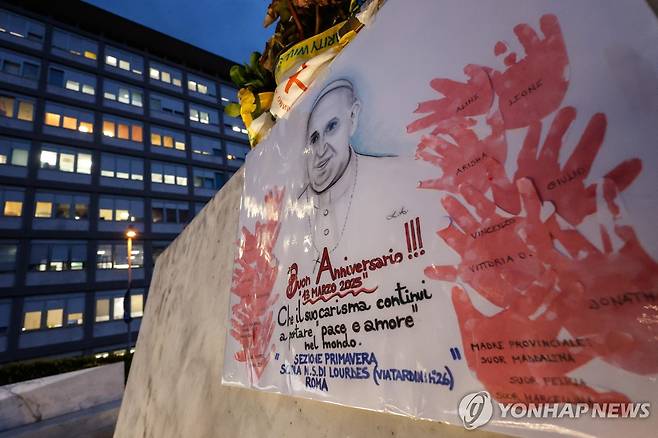 교황 즉위 12주년 (로마 EPA=연합뉴스) 13일(현지시간) 이탈리아 로마 제멜리 병원 입구에 있는 요한 바오로 2세 동상에 프란치스코 교황의 즉위 12주년을 기념하는 배너가 걸려 있다. 2025.03.13 photo@yna.co.kr