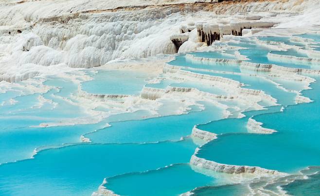 온천수가 흘러내리면서 마치 계단식 논처럼 각기 다른 형태의 자연 온천장을 만들었다. [GettyImages]