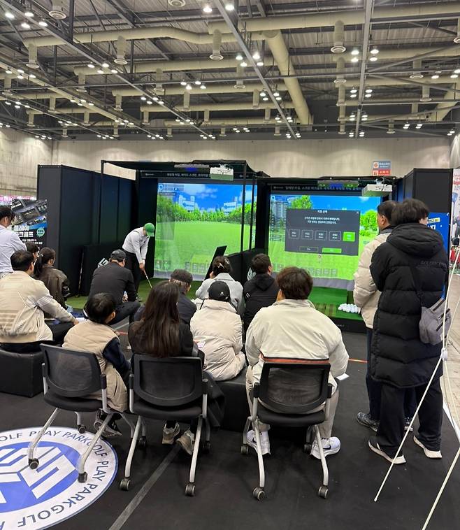 '플레이 파크골프' 부스에서 스크린 파크골프 시연을 지켜보는 관람객. 지티에스앤