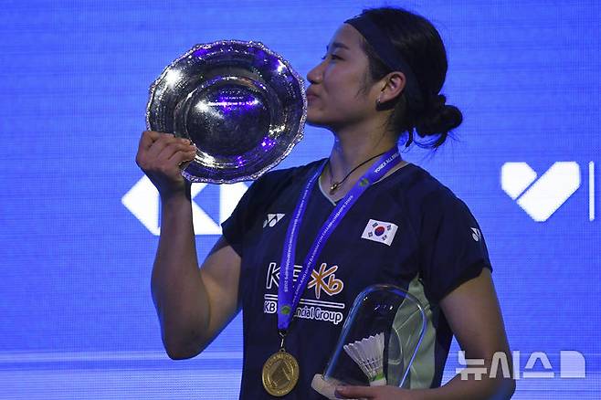 [버밍엄=AP/뉴시스] 안세영이 16일(현지 시간) 영국 버밍엄의 유틸리타 아레나에서 열린 세계배드민턴연맹(BWF) 전영오픈 여자 단식 정상에 올라 트로피에 입 맞추고 있다. 안세영은 결승에서 왕즈이(중국)를 2-1(13-21 21-18 21-18)로 꺾고 정상에 올랐다. 2025.03.17.