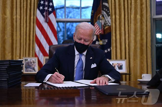 조 바이든 전 미국 대통령이 서명하고 있다. ⓒ AFP=뉴스1
