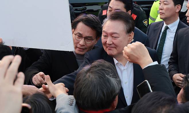 지난 8일 서울구치소에서 석방된 윤석열 대통령이 서울 한남동 관저 앞에서 차량에서 내려 지지자들과 악수하고 있다. 연합뉴스