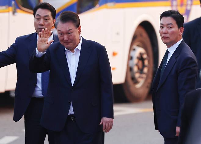 석방된 윤석열 대통령이 3월8일 경기도 의왕시 서울구치소 앞에서 경호차량에서 내려 지지자들에게 인사하고 있다. 그 옆으로는 김성훈 경호처 차장(오른쪽)이 윤 대통령을 경호하며 이동하고 있다. ⓒ 연합뉴스