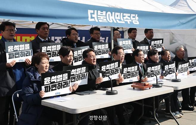 이재명 대표 등 더불어민주당 지도부가 19일 서울 광화문 천막농성장에서 열린 현장 최고위원회의에서 손팻말을 들고 구호를 외치고 있다. 국회사진기자단