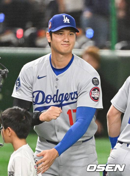 [OSEN=도쿄(일본), 박준형 기자] 18일 오후 일본 도쿄돔에서 메이저리그 공식 개막전 2025 도쿄시리즈 LA 다저스와 시카고 컵스의 경기가 진행됐다. 이번 도쿄시리즈가 기존 해외시리즈에 비해 더 큰 관심을 모으고 있는 것은 역시 LA 다저스와 시카고 컵스에 있는 일본 선수들 때문. LA 다저스에는 메이저리그 최고 슈퍼스타 오타니 쇼헤이를 비롯해 야마모토 요시노부와 사사키 로키가 있다. 또 시카고 컵스에는 이마나가 쇼타, 스즈키 세이야가 있다.   경기에 앞서 오프닝행사 뒤 LA다저스 오타니가 시카고 컵스 선수단을 향해 주먹을 쥐머 보이고 있다.  2025.03.18 / soul1014@osen.co.kr