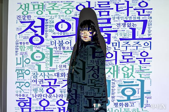 2030 청년정치네트워크 ‘전진하는민주주의 밸리드’ 공동대표 양소희씨가 3월4일 서울 중구 <시사IN> 편집국 회의실에서 카메라를 응시하고 있다. 양씨 뒤의 화면에 띄워진 단어들은 청년 2459명이 제출한 탄핵 촉구 의견서 ’내가 원하는 미래’에 쓰인 것이다. ⓒ시사IN 박미소