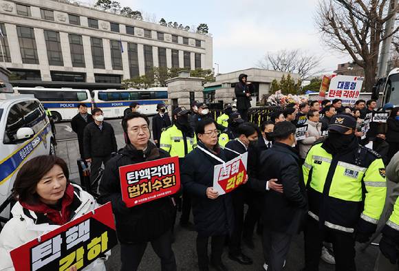 윤석열 대통령 탄핵심판 선고일 발표가 늦어지고 있는 가운데 20일 서울 종로구 헌법재판소 앞에서 국민의힘 나경원, 김민전, 강민국, 이만희 의원이 릴레이 시위를(왼쪽), 더불어민주당 박성준 원내운영수석부대표와 김용민 원내정책수석부대표 등 원내부대표단이 윤 대통령의 신속한 파면을 촉구하는 기자회견을 하고 있다. [사진=연합뉴스]