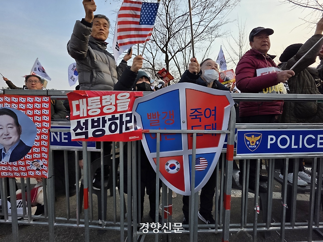 지난 7일 경기 의왕시 서울구치소 앞에 윤석열 대통령 지지자들이 “빨갱이는 죽여도 돼”라는 문구가 적힌 팻말을 들고 있다. 오동욱 기자
