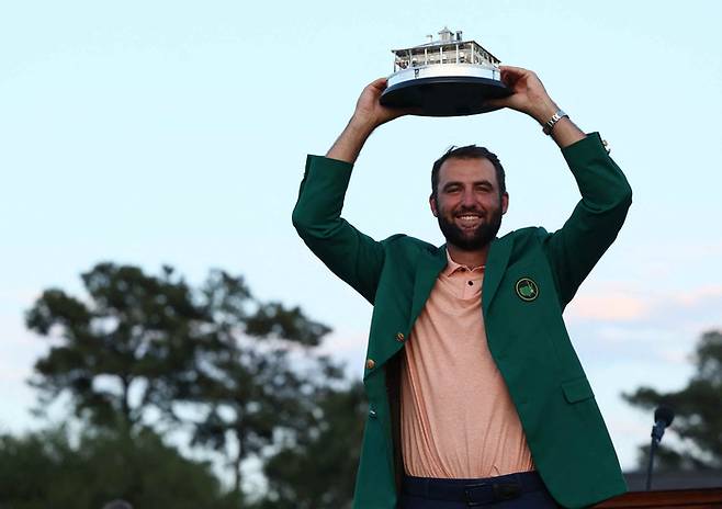 지난해 마스터스 토너먼트에서 우승을 차지한 스코티 셰플러가 그린재킷을 입은 채 트로피를 번쩍 들어올리고 있다. AFP연합뉴스