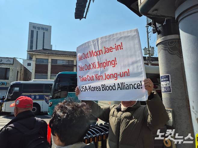 윤 대통령 지지자가 'Take Out Xi Jinping!'이라고 쓰여진 영어 손팻말을 들고 있다. 나채영 기자