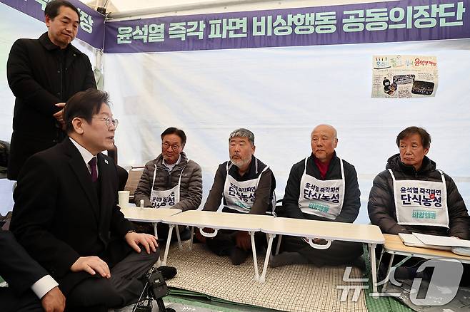 이재명 더불어민주당 대표와 지도부가 21일 서울 종로구 광화문 인근 윤석열즉각퇴진·사회대개혁 비상행동(비상행동) 단식농성장을 찾아 윤 대통령 파면을 촉구하며 14일째 단식 중인 공동의장단들을 만나 대화하고 있다. (공동취재) 2025.3.21/뉴스1 ⓒ News1 임세영 기자