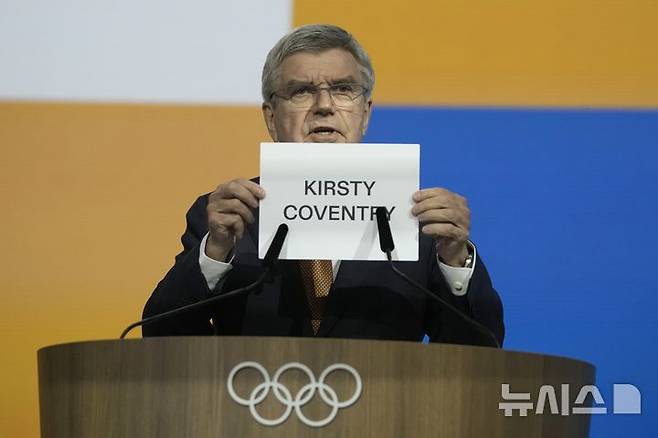 [코스타 나바리노(그리스)=AP/뉴시스] 20일(현지 시간) 그리스 코스타 나바리노에서 열린 제144차 총회에서 토마스 바흐IOC 위원장이 제10대 국제올림픽위원회(IOC) 위원장으로 선출된 커스티 코번트리를 호명하고 있다. 2025.03.21.