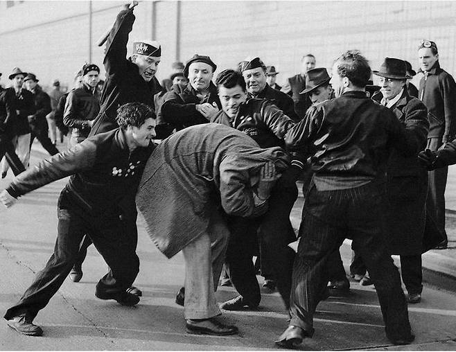 '곧 일이 터지겠군' 1942년 수상작, 피켓 라인(THE PICKET LINE)밀턴 브룩스 Milton BrooksApril 3, 1941, Detroit, Mich. 저작권 Alamy Stock Photo.  포드 자동차 공장에서 12만 명이 파업에 들어간 상황. 한 장의 사진으로 승부를 보는 브룩스 기자는 '순간'이 곧 다가올 것을 직감했다. 그곳에 시위 반대 세력들이 있었기 때문이다. 군중 속에서 목소리가 커지더니, 8명의 사내가 주먹과 몽둥이로 한 노동자를 폭행하기 시작했다. 브룩스는 카메라를 코트에 숨긴 채 군중 속에 파고들어 사진을 찍었다.  *재판매 및 DB 금지