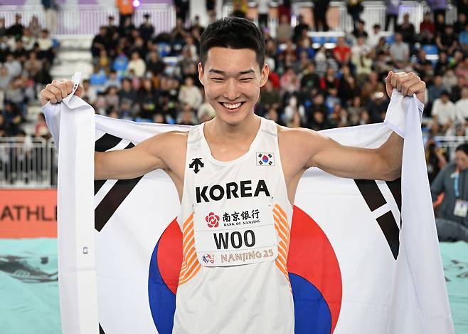 우상혁이 21일 중국 난징 유스올림픽스포츠파크에서 열린 2025 세계실내선수권 남자 높이뛰기 결선에서 우승한 뒤 태극기 세리머니를 하고 있다.  난징 | 신화연합뉴스