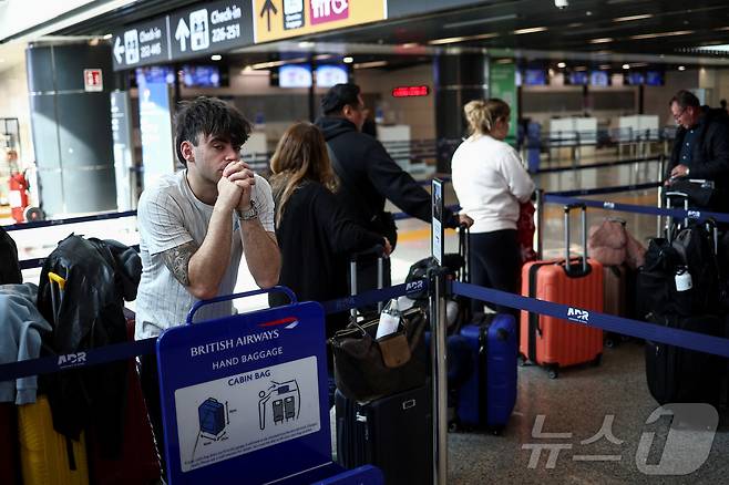 21일(현지시간) 한 승객이 이탈리아 로마의 피우미치노 국제공항에서 자신이 탑승할 영국 런던 히드로공항으로 가는 항공편 관련 소식을 기다리고 있다. 이날 히스로공항은 인근 변전소 화재로 전면 폐쇄됐다. 2025.03.21 ⓒ 로이터=뉴스1 ⓒ News1 김지완 기자