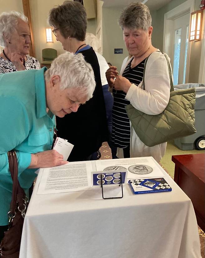 /스테이시 박 밀번 가족 지난 15일 뷸라 밀번의 영결식장을 찾아온 손님들이 고인의 손녀로 먼저 세상을 뜬 스테이시 박 밀번을 기린 동전 세트를 살펴보고 있다.