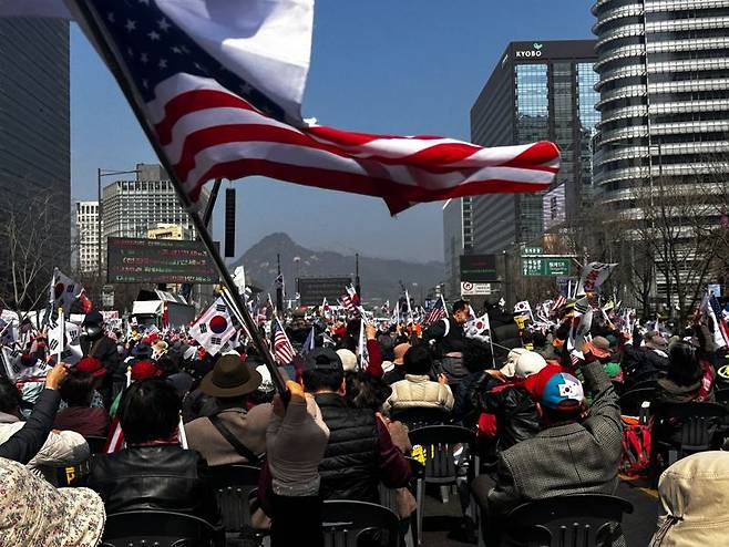 22일 윤석열 대통령 탄핵 반대 집회에 참석한 인원들이 태극기와 성조기를 흔들고 있다. 사진=정경수 기자