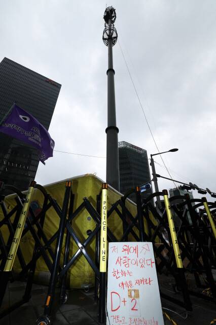 김형수 금속노조 거제통영고성조선하청지회장이 원청인 한화오션에 임금 직접 교섭을 요구하며 서울 중구 한화빌딩 앞 30m 높이 CCTV 관제탑에 올라가 있다. 한겨레 김영원 기자 forever@hani.co.kr