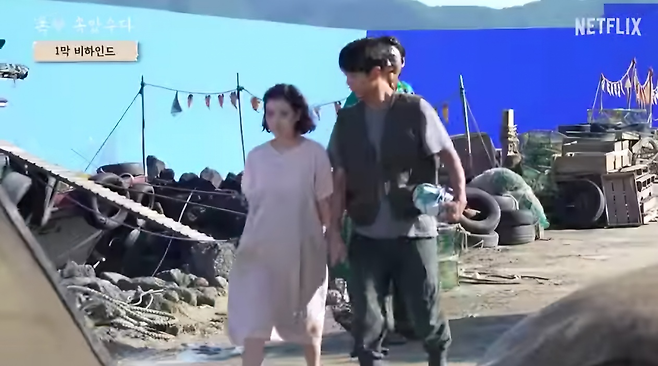 넷플릭스 오리지널 드라마 ‘폭삭 속았수다’ 촬영 현장. 블루 스크린을 치고 촬영하고 있다. CG작업을 통해 이 부분은 실제 영상에선 바다로 묘사됐다. [넷플릭스 유튜브 갈무리]