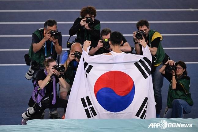 우상혁이 우승 확정 후 태극기를 들고 기념 촬영을 하고 있다. /AFPBBNews=뉴스1