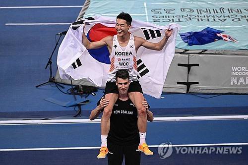 커의 어깨 위에서 환하게 웃는 우상혁 [AFP=연합뉴스 자료사진]