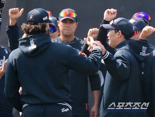 박상원이 민망한 표정으로 폰세의 손을 잡아 내리고 있다.